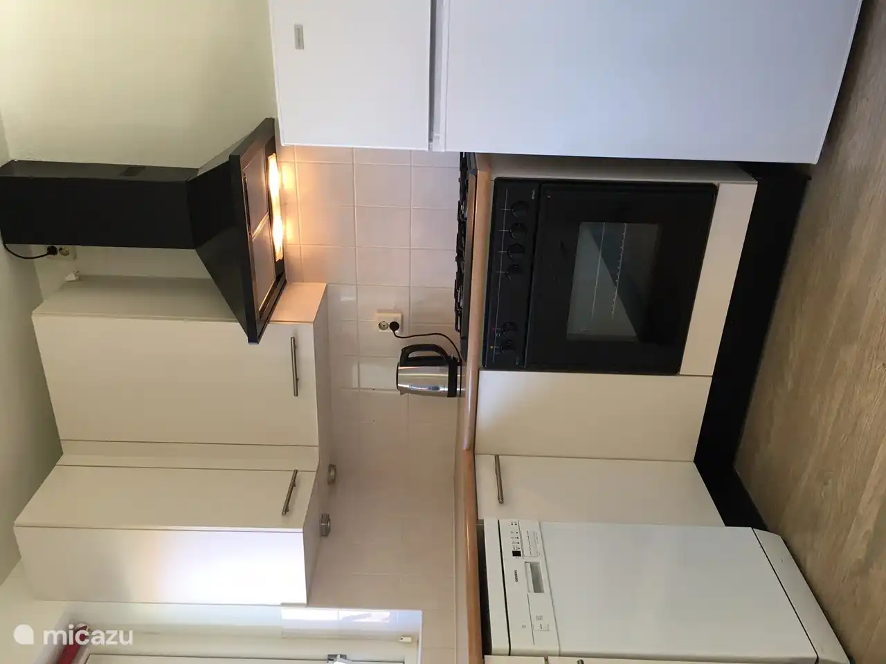 Keuken met vaatwasser, fornuis, oven en koel/vriescombinatie.