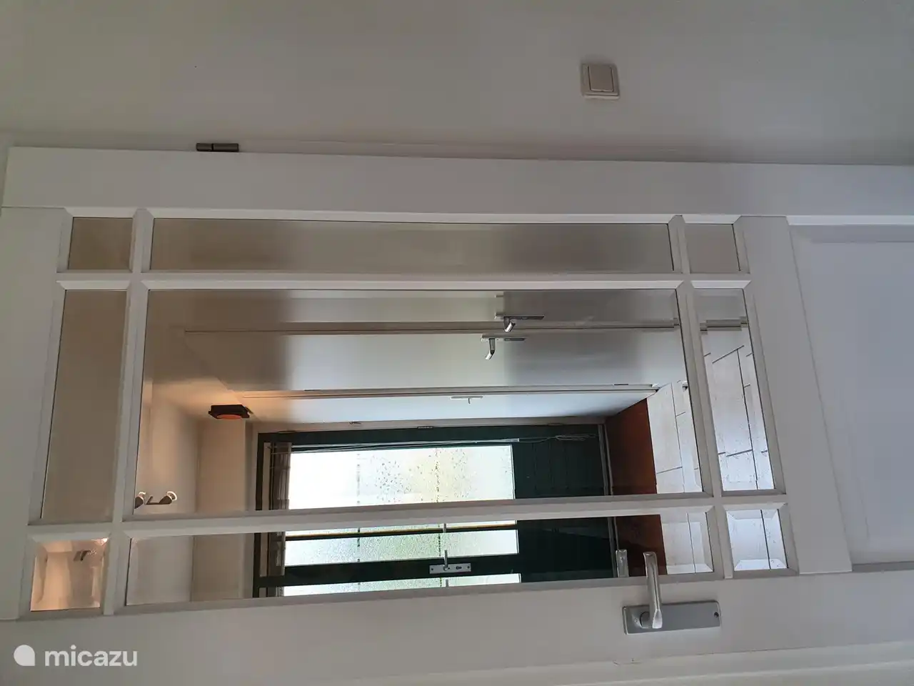 Hal met zicht op voordeur, deur badkamer en deur toilet.