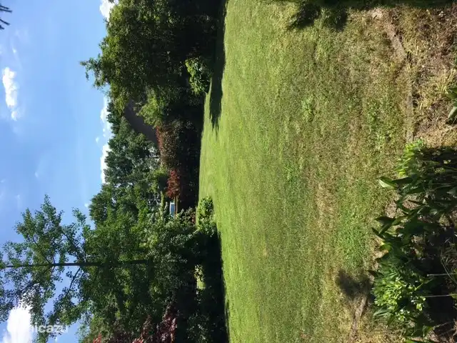 Groot grasveld in het gedeelte van de tuin rechts naast het huis.