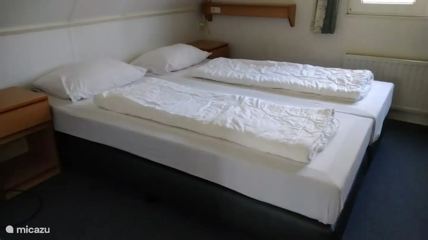une chambre, avec deux lits avec un matelas à ressorts ensachés pour un confort de couchage idéal, hauteur de couchage d'environ 55 centimètres