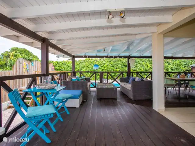 Location de Vacances Curaçao, Banda Ariba (est), Jan Thiel, maison de vacances - Kas Granjero La véranda, un endroit merveilleux pour vivre à l'extérieur. Derrière la véranda se trouve la piscine. C'est un endroit agréable pour manger à l'ombre, jouer à des jeux, se détendre ou lire un livre.