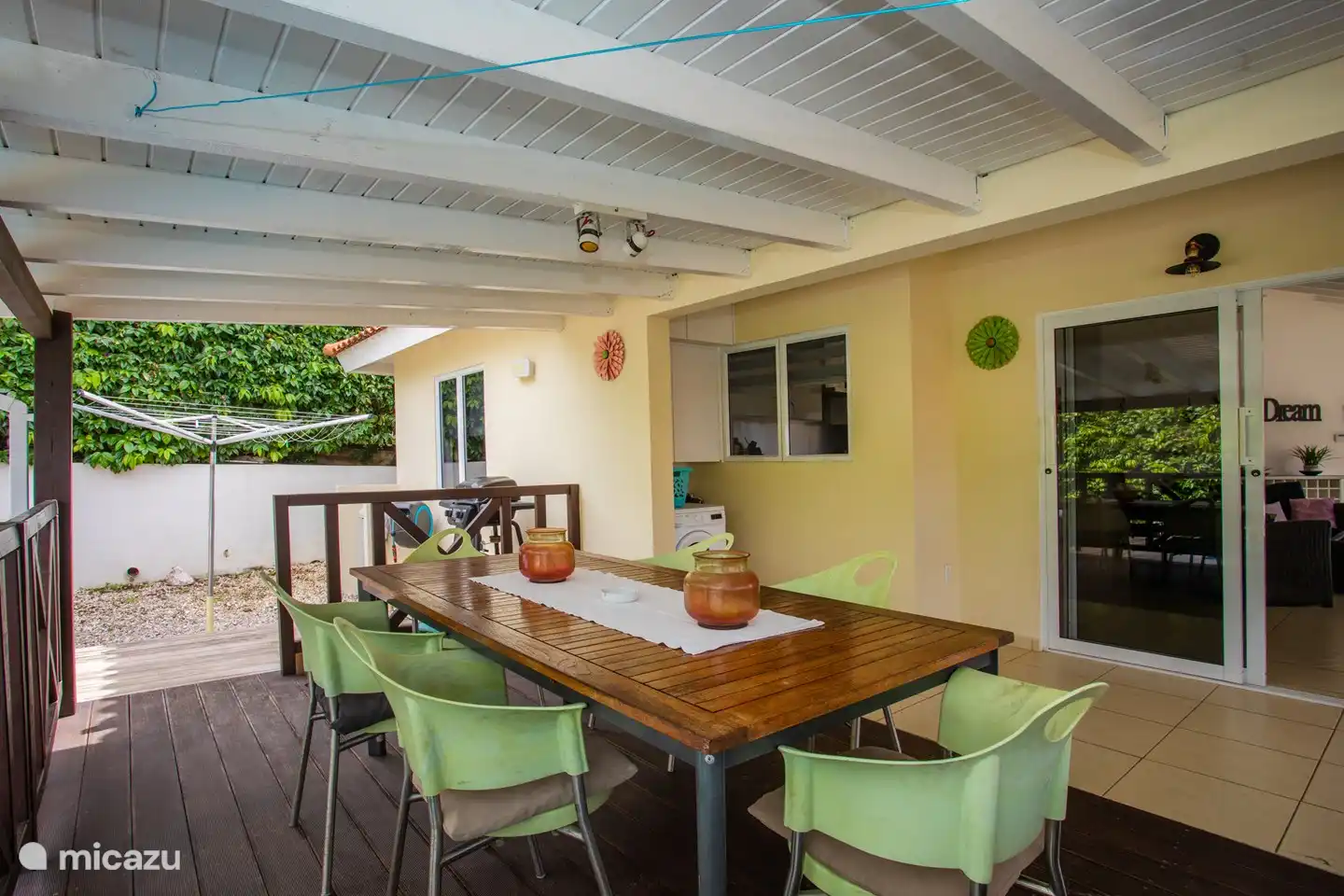 La veranda, un maravilloso lugar para vivir al aire libre. Detrás de la terraza está la piscina. Es un buen lugar para comer a la sombra, jugar, relajarse o leer un libro.