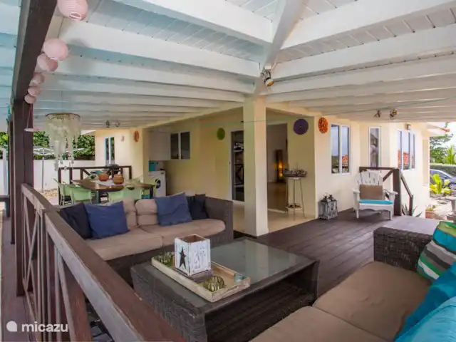 Location de Vacances Curaçao, Banda Ariba (est), Jan Thiel, maison de vacances - Kas Granjero La véranda, un endroit merveilleux pour vivre à l'extérieur. Derrière la véranda se trouve la piscine. C'est un endroit agréable pour manger à l'ombre, jouer à des jeux, se détendre ou lire un livre.