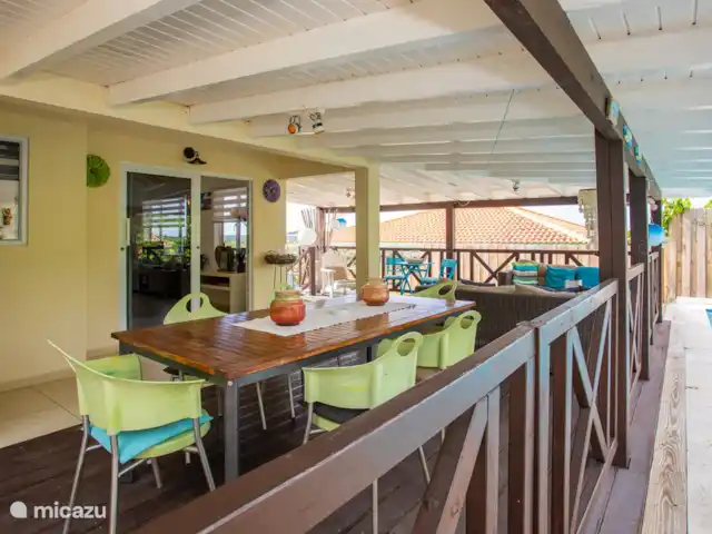 Location de Vacances Curaçao, Banda Ariba (est), Jan Thiel, maison de vacances - Kas Granjero La véranda, un endroit merveilleux pour vivre à l'extérieur. Derrière la véranda se trouve la piscine. C'est un endroit agréable pour manger à l'ombre, jouer à des jeux, se détendre ou lire un livre.