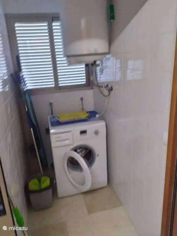 Débarras avec machine à laver, matériel de nettoyage, espace de rangement