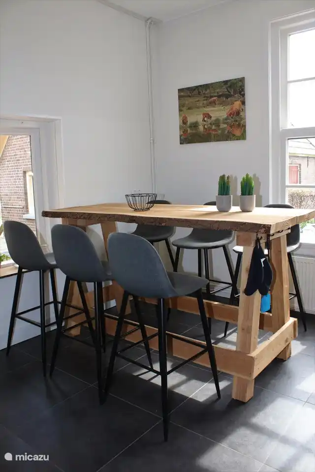 In der Küche steht ein Stehtisch mit 6 Barhockern daran befestigt.