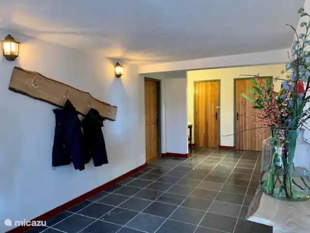 Granja de vacaciones De Steeg en Países Bajos, Güeldres, De Steeg - casa de campo Al entrar se accede al gran recibidor con perchero y congelador. Aquí también está el aseo y un trastero. Si caminas por el pasillo, ingresas al antiguo establo donde ahora pueden jugar los niños.