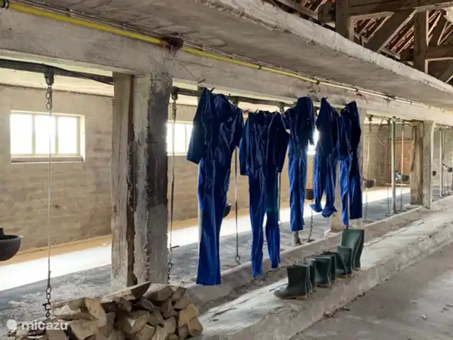 Granja de vacaciones De Steeg en Países Bajos, Güeldres, De Steeg - casa de campo Por parte está la leña para la estufa de leña y hay un par de botas y varios overoles.