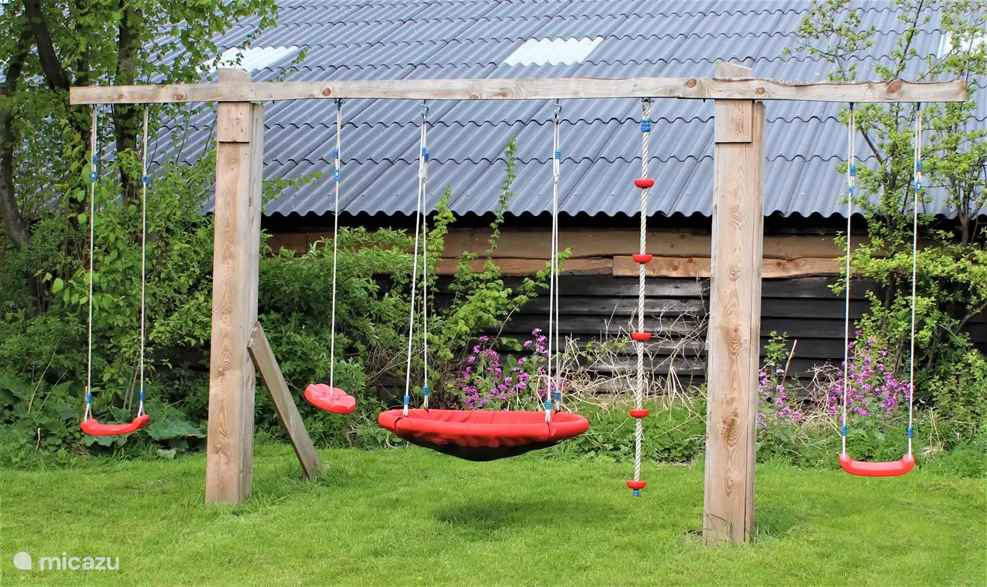 Im Garten befinden sich zwei Schaukeln und ein Schaukelkorb