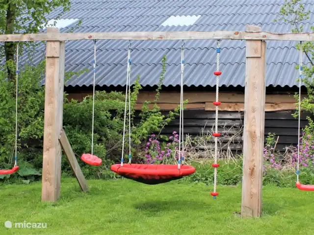 Granja de vacaciones De Steeg en Países Bajos, Güeldres, De Steeg - casa de campo Hay dos columpios y una canasta de columpios en el jardín.