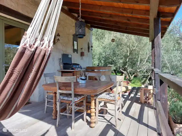 Location de Vacances Grèce, Crète, Koutsouras, gîte / cottage - Kalyvitis Cottage dans l’oliveraie 2 Adami dispose d’une grande terrasse avec un hamac pour 2 personnes, une plaque de gril, un bain froid et une grande table à manger.