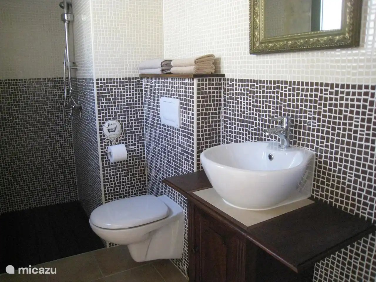 Das Badezimmer verfügt über eine geräumige Dusche, Toilette und Waschbecken.