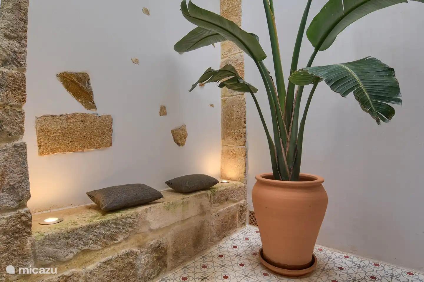 Peque&#241;o patio con un bonito asiento en el arco de tosca.