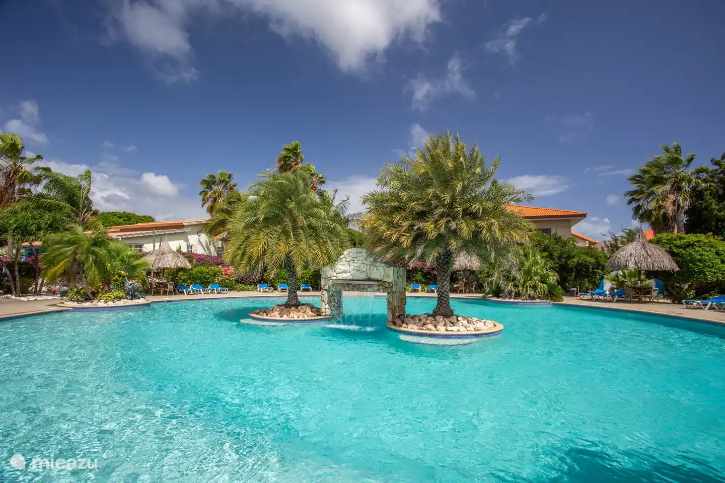 swimming pool with palm islands and waterfall