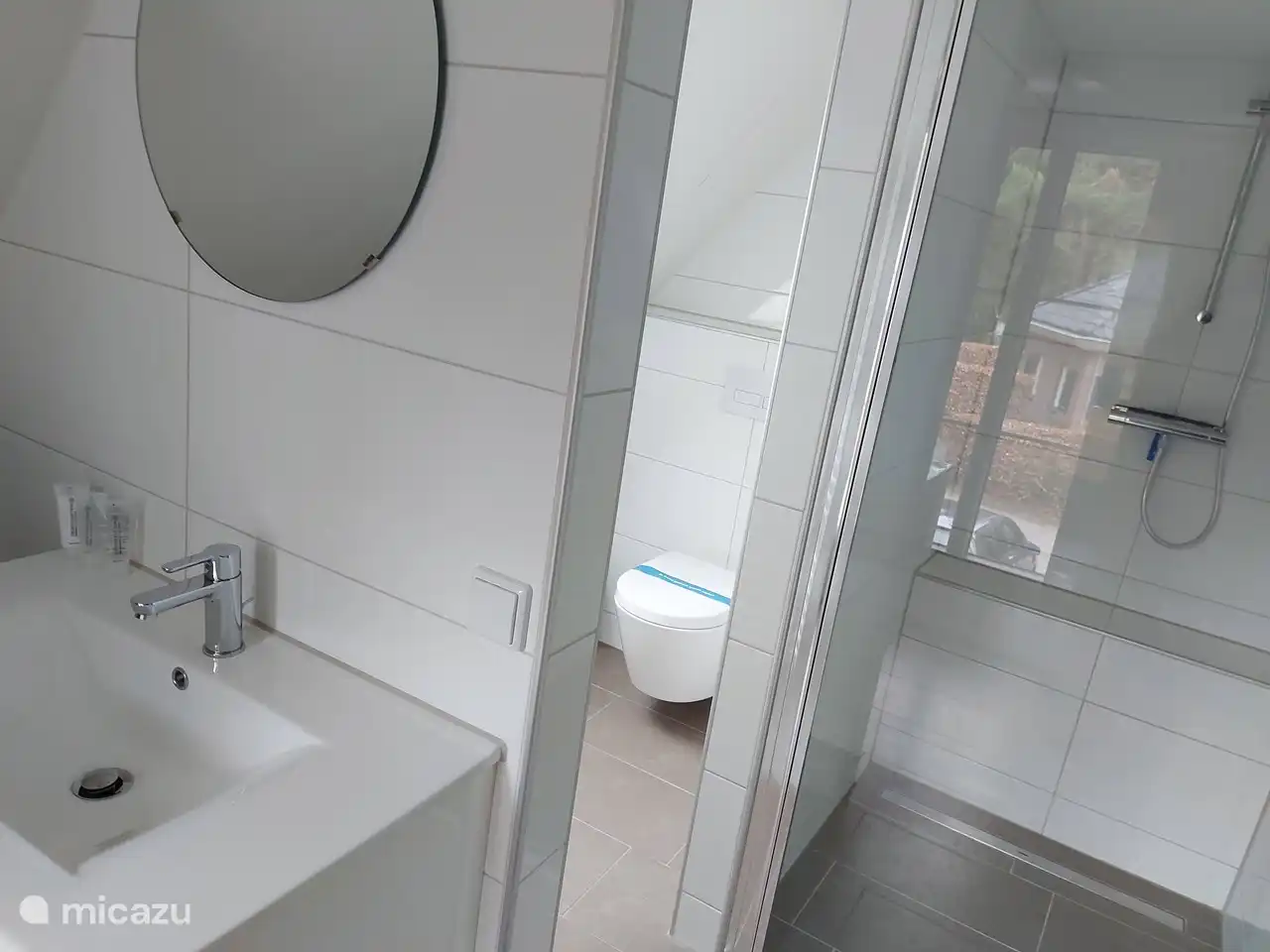 Cuarto de baño primer piso con baño con inodoro, ducha y lavabo.