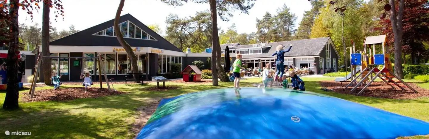 Parque infantil y cama elástica junto a la terraza