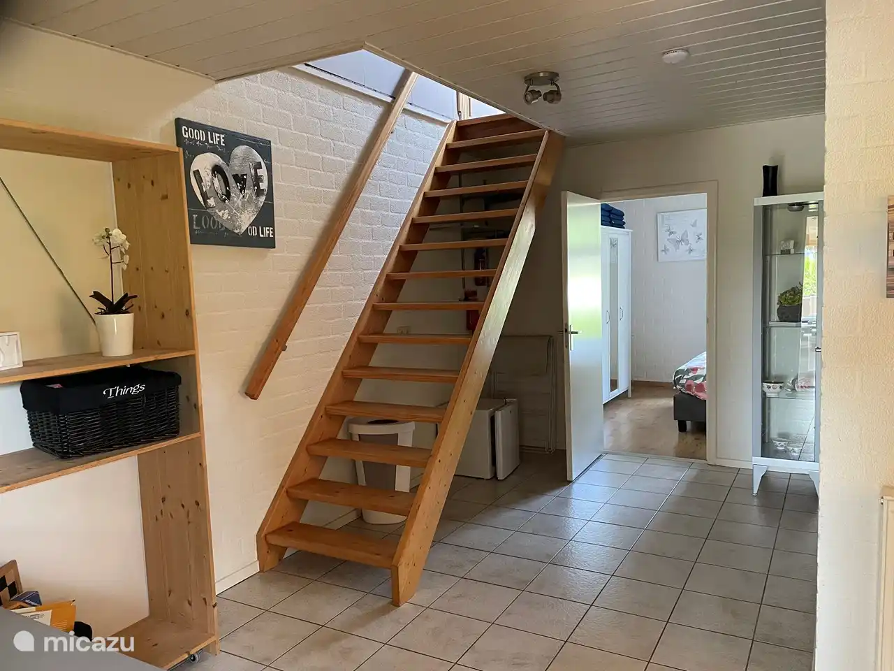 Lobby / Treppe zum Schlafzimmer im Obergeschoss, kleiner Gefrierschrank vorhanden. Zugang zu Bad und WC. Die Eingangstür hat eine Fliegengittertür.