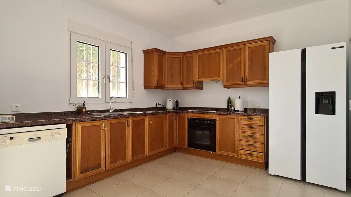 Keuken boven met Amerikaanse koelkast, voorzien van een waterdispenser.