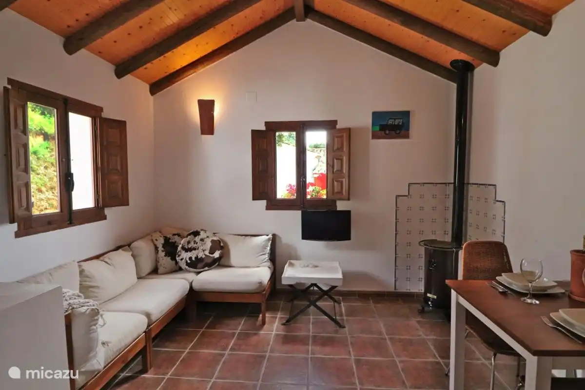 Das Wohnzimmer mit Sitzecke, Essbereich und Holzofen für die kühleren Momente