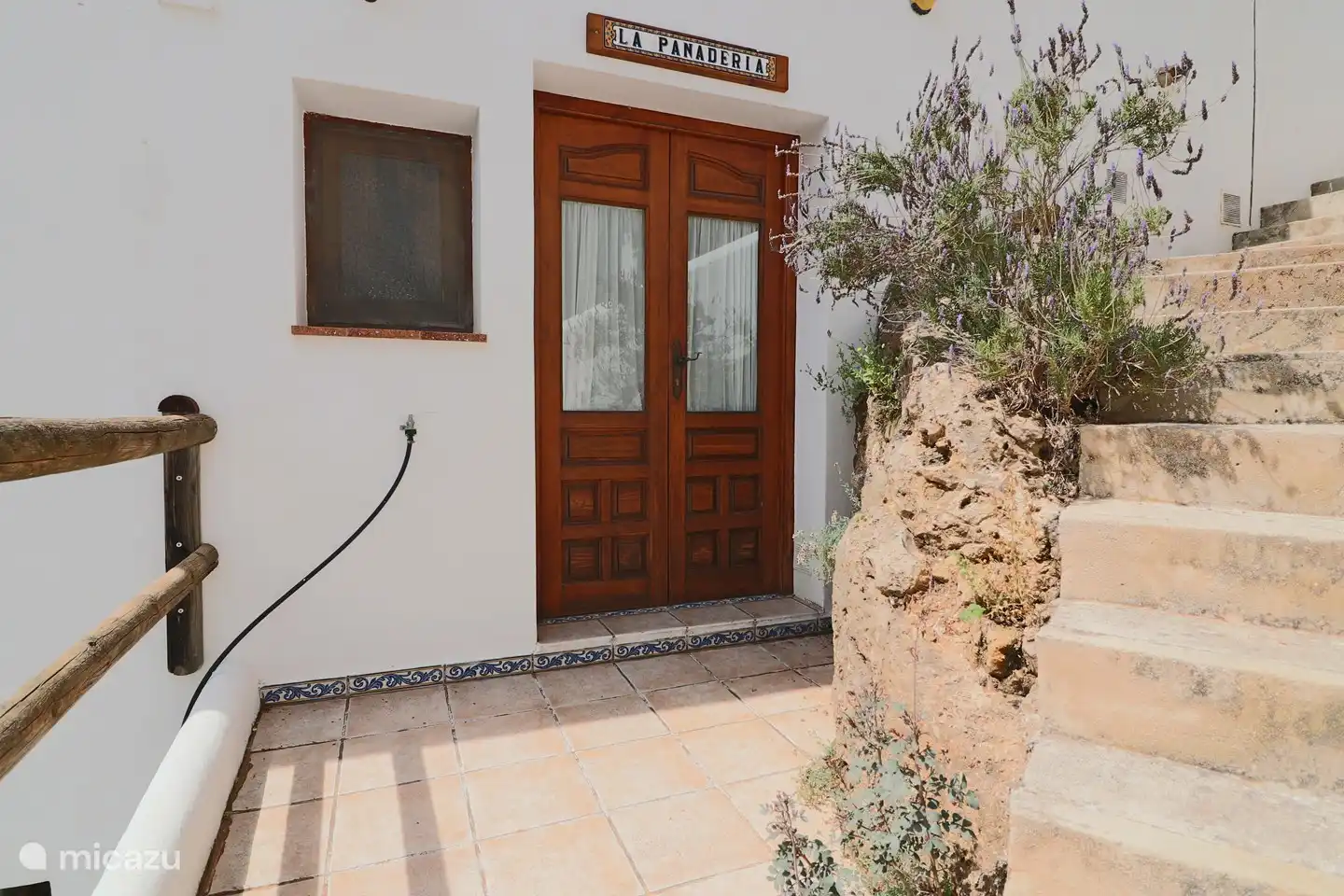 La Panadería hat einen eigenen Eingang über eine Treppe zur doppelten Eingangstür
