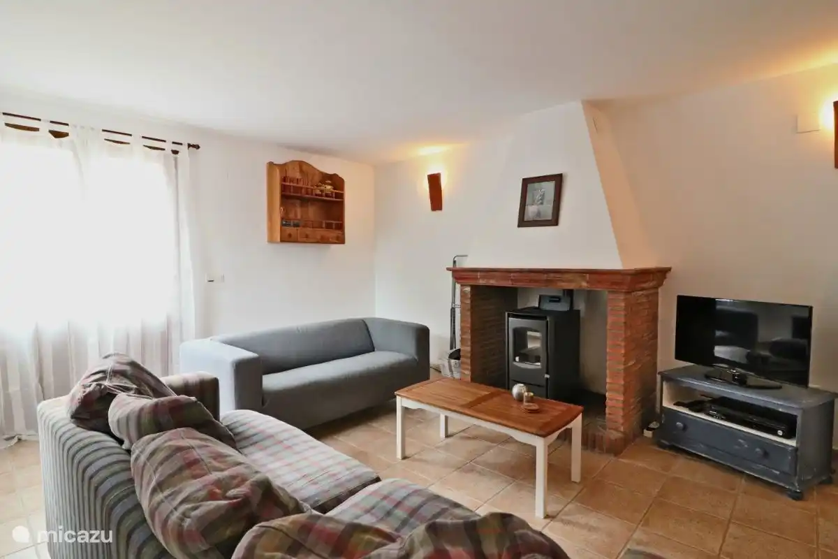 Das Wohnzimmer mit Pelletofen für die kühleren Tage und die Terrassentüren zur Terrasse