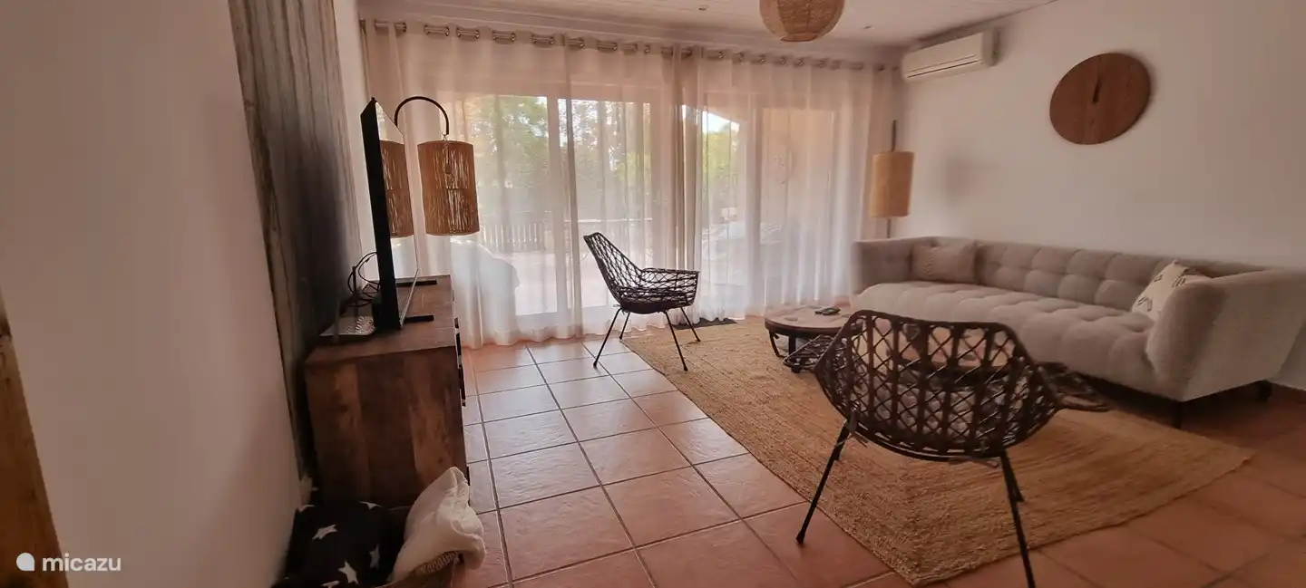 The comfortable and cozy open living room with sliding doors to the terrace