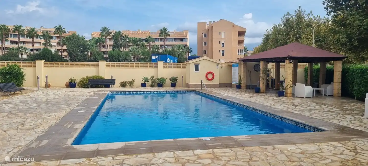 The swimming pool with terrace and various seating areas.