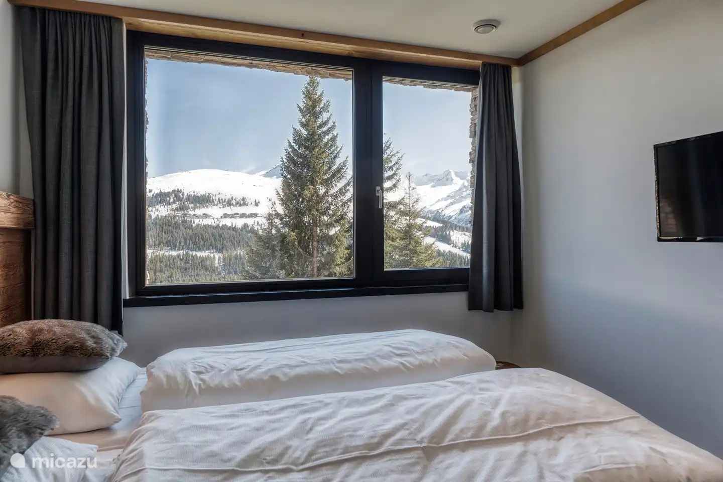 Slaapkamer 1 met boxspringbed en smart TV.