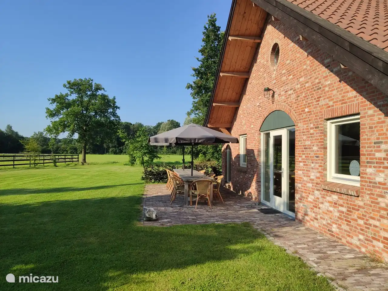 Terrasse mit Blick über Felder, auf denen abends regelmäßig Rehe grasen.