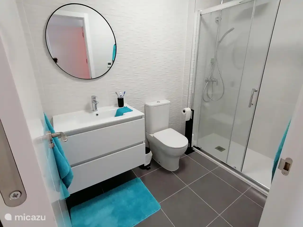 salle de bain 2 avec un meuble lavabo et toilettes et des serviettes dans les tiroirs du lavabo