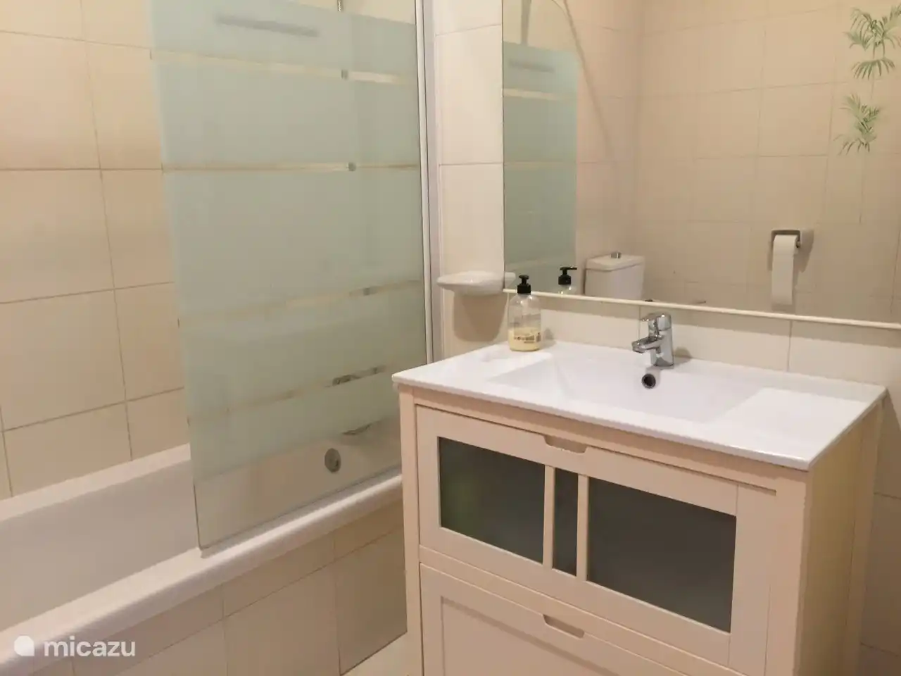 grande salle de bain avec lavabo, baignoire avec moustiquaire et douche, toilettes et bidet