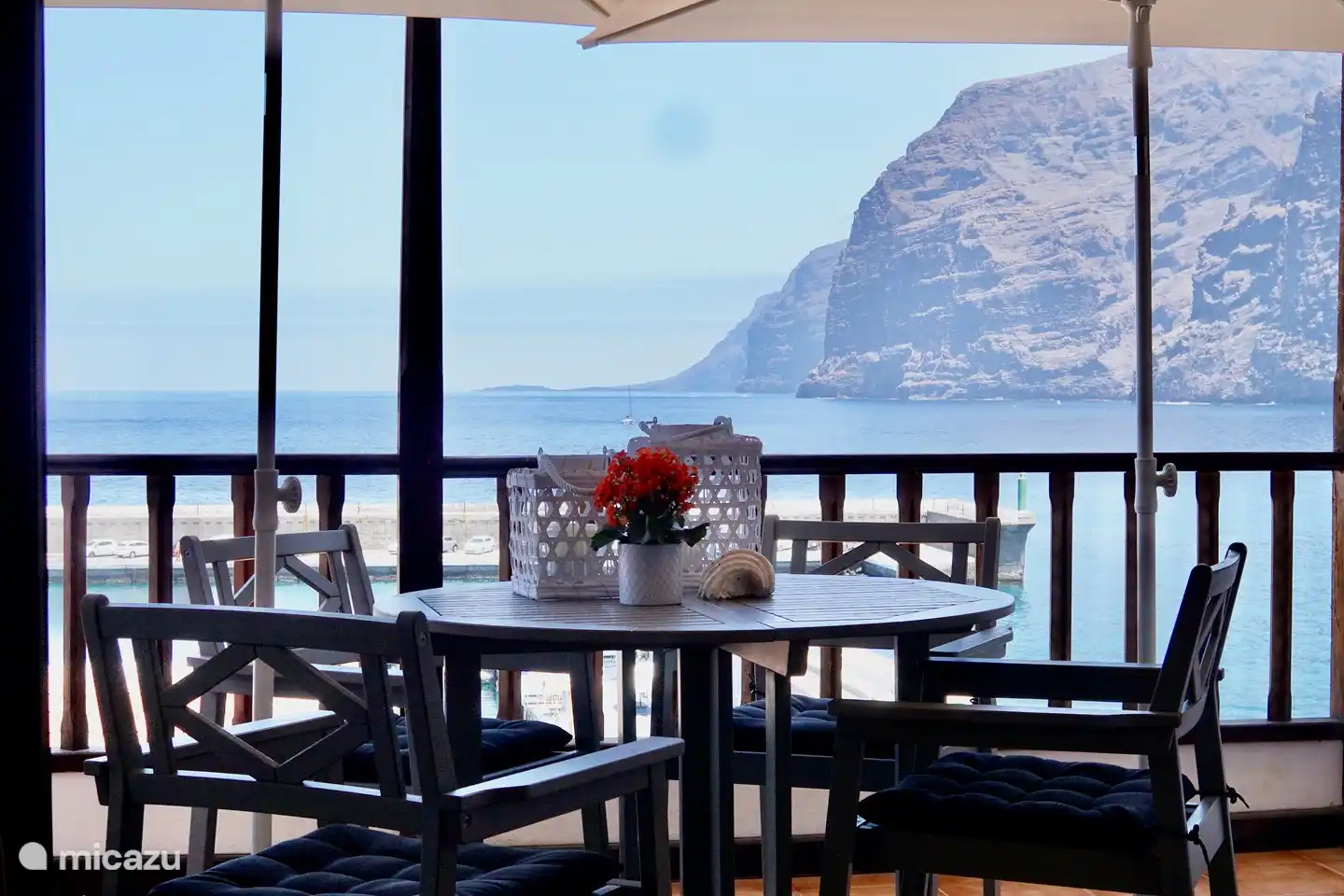 Notre terrasse à l’avant avec vue sur le port et l’océan devant, et à droite sur les rochers et la plage