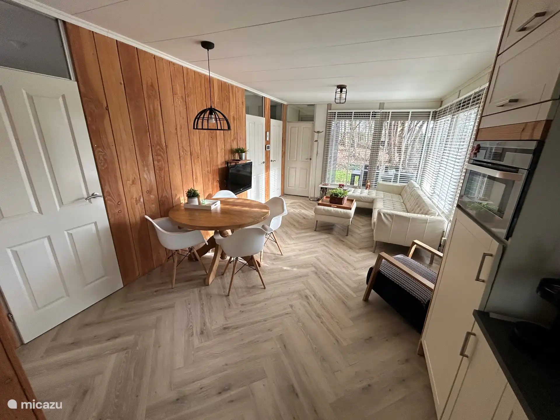 woon/eetkamer met veel lichtinval en uitzicht op de tuin