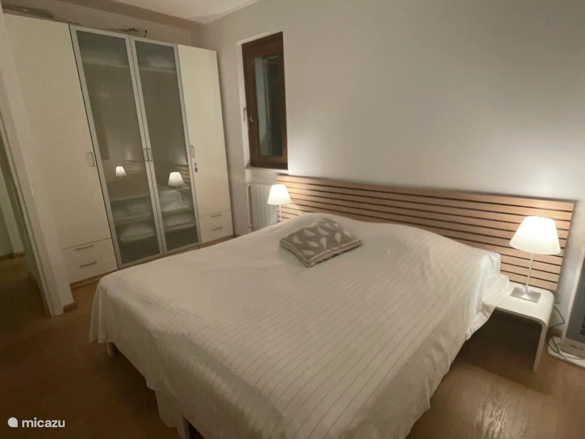 A nice Auping bed with a view of the wardrobe with extra pillows and
Duvets.