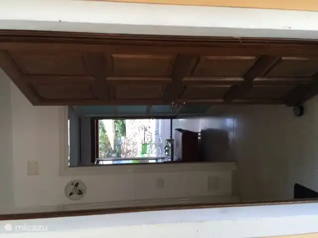 You walk into the hall with a view through the living room to the terrace.