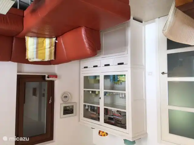 The cupboard with a variety of Dutch books and underneath space for crockery and glassware.
