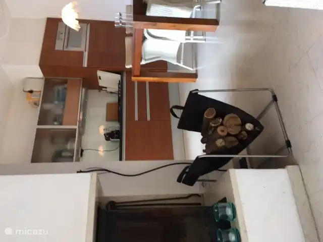 View of our kitchen with in the front left our fireplace with logs as standard, dining table with loom chairs.