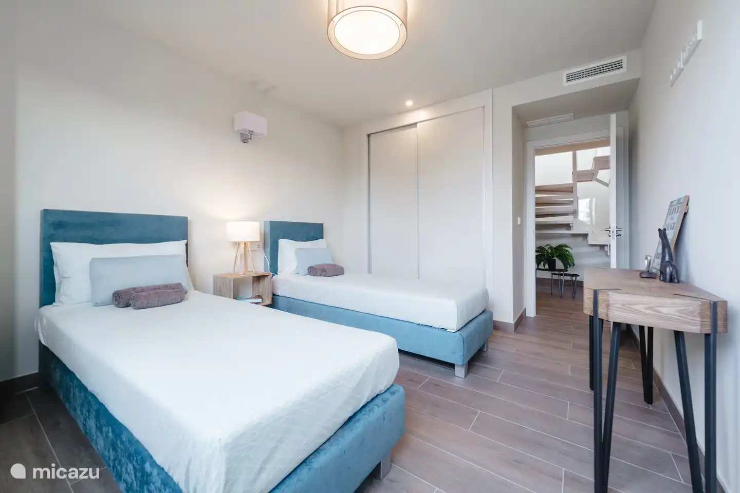 Bedroom with two single beds and fitted wardrobe.