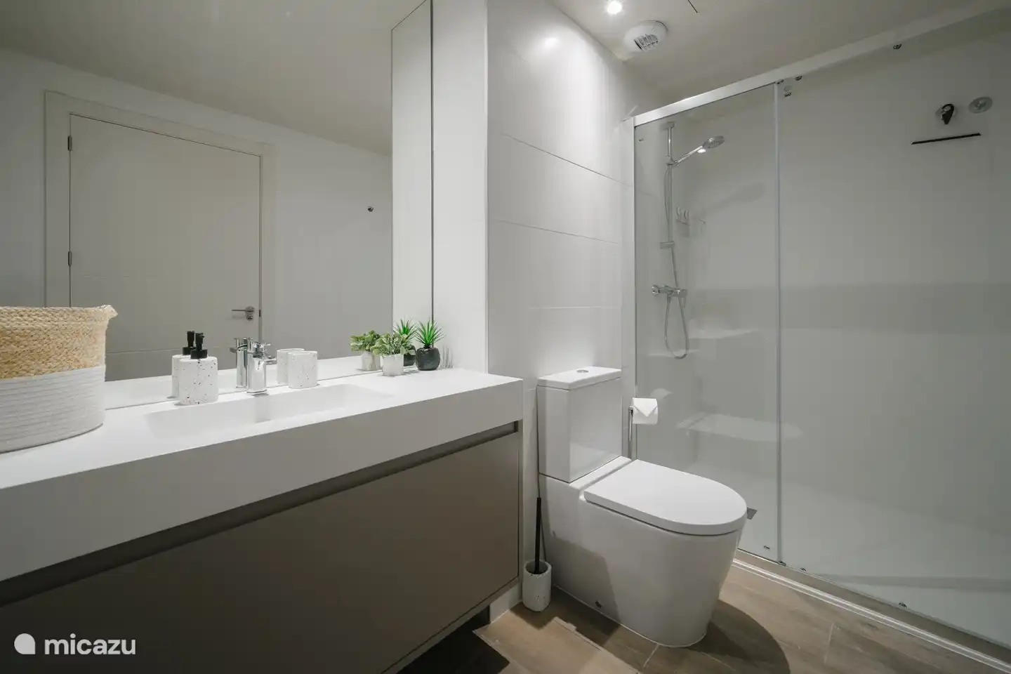 Spacious, modern bathroom with sink, toilet and walk-in shower.