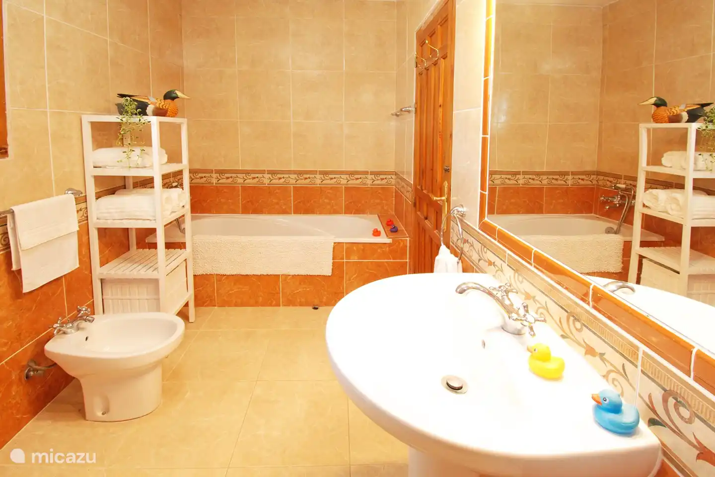 Hauptbadezimmer mit geräumiger ebenerdiger Dusche, Badewanne, Bidet und WC.