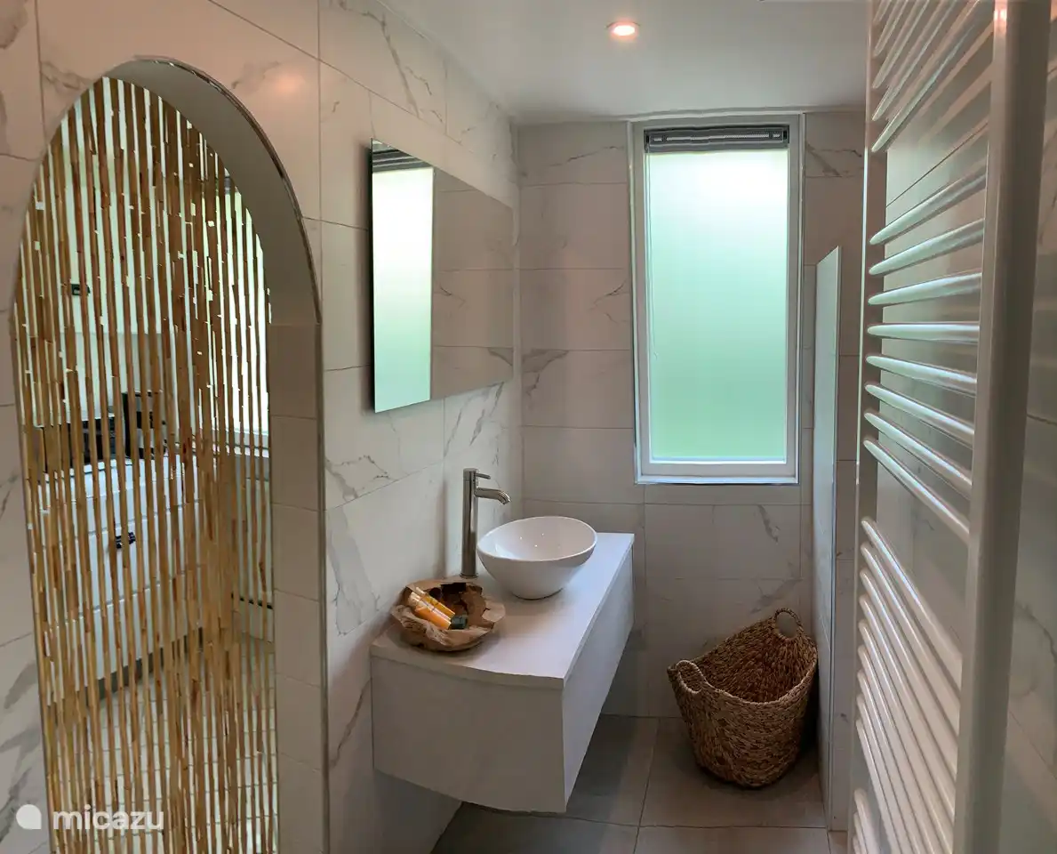 Kürzlich renoviertes Badezimmer im Erdgeschoss, hinter dem Bambusvorhang ein geräumiger Hauswirtschaftsraum, komplett gefliest mit Küchenzeile, hier befindet sich auch die Waschmaschine, es gibt viel Platz für alle Toilettenartikel