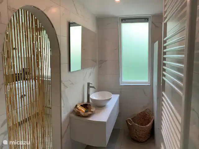 Maison forestière Nunspeet B40 | Pays-Bas, Gueldre, Nunspeet - maison de vacances salle de bain récemment rénovée au rez-de-chaussée, derrière le rideau de bambou une buanderie spacieuse, entièrement carrelée avec kitchenette, voici aussi la machine à laver, il y a beaucoup d'espace pour tous les articles de toilette