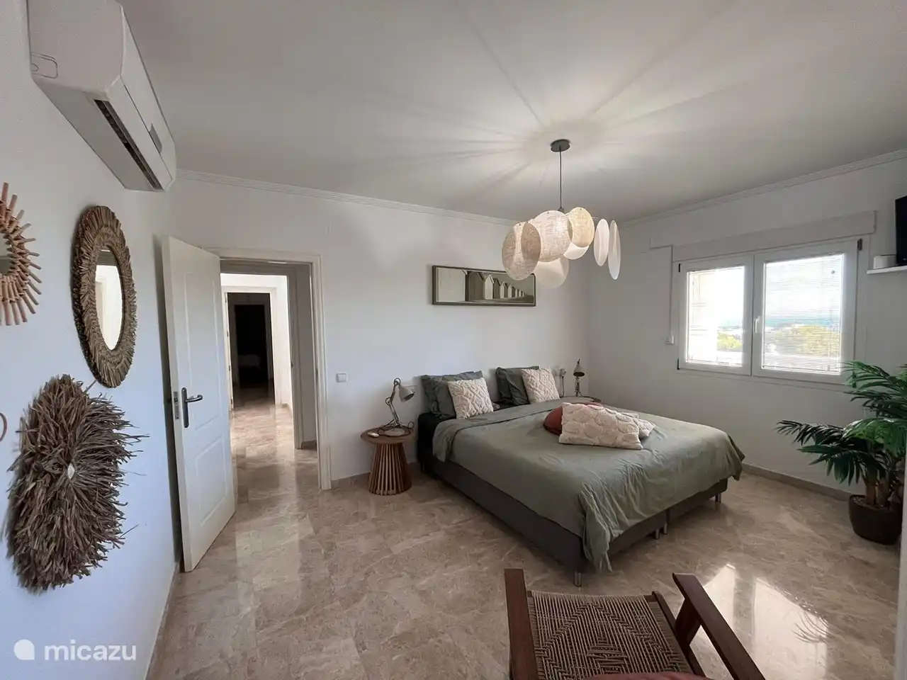 Schönes Hauptschlafzimmer mit angrenzendem Badezimmer. Blick auf den Pool