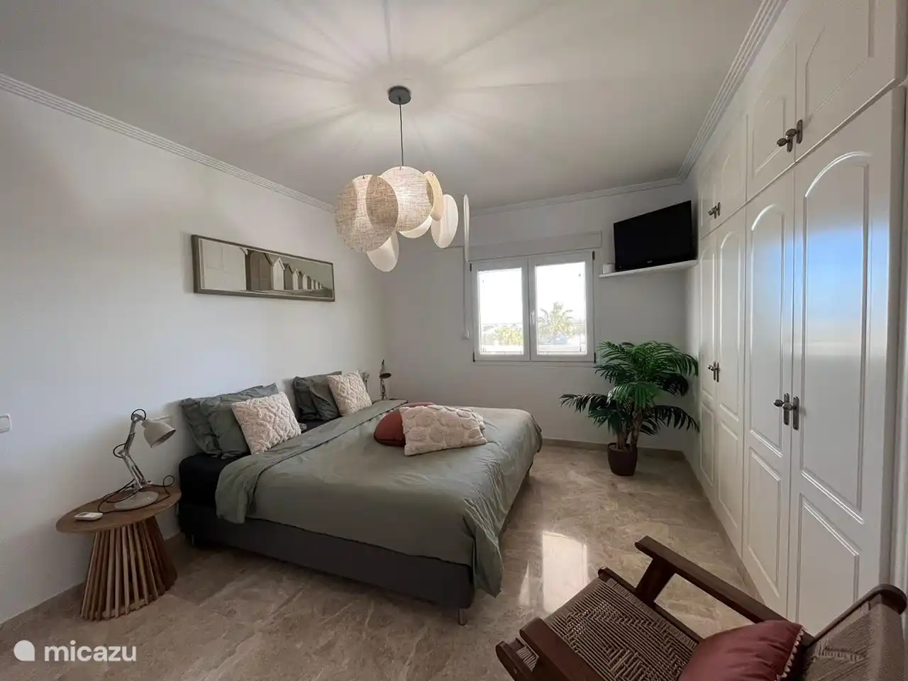 Hauptschlafzimmer mit angrenzendem Badezimmer. Blick auf den Pool.