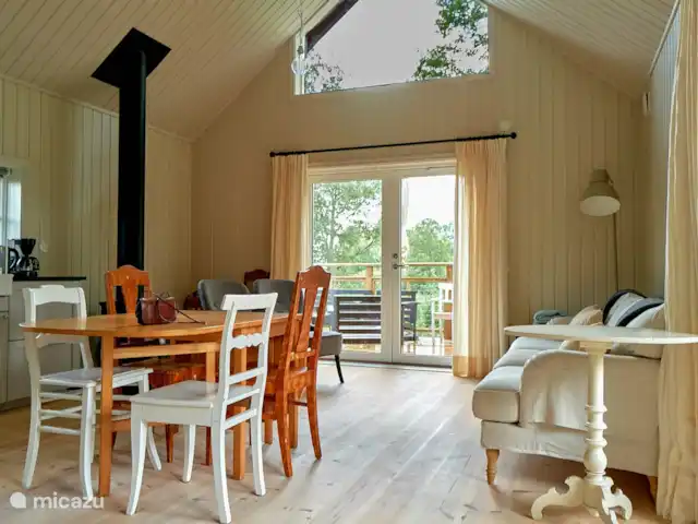 Chalet du lac Agundaborg | Suède, Småland, Ljungby - gîte / cottage Le salon avec cuisine ouverte, une belle cheminée et une vue magnifique sur le lac et la nature
