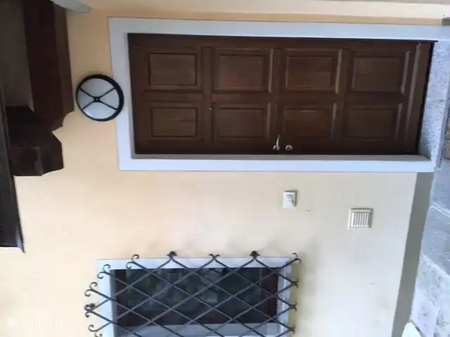 The front door with artfully forged fencing in front of the window