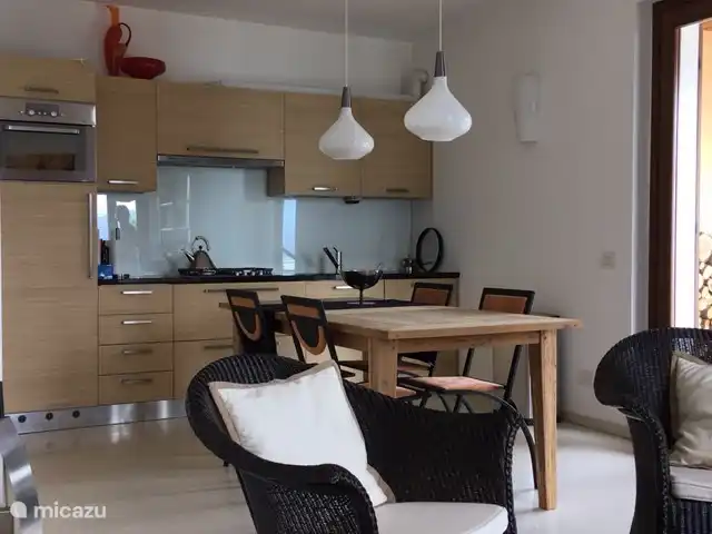 Cannobio-Lago Maggiore S.Carmine 1A en Italia, Piamonte, Carmine Inferiore - casa vacacional cocina con frigorífico, horno mixto, lavavajillas y zona de cocina (gas). mesa de comedor con sillas modernas.
a la derecha las puertas del patio a la terraza.