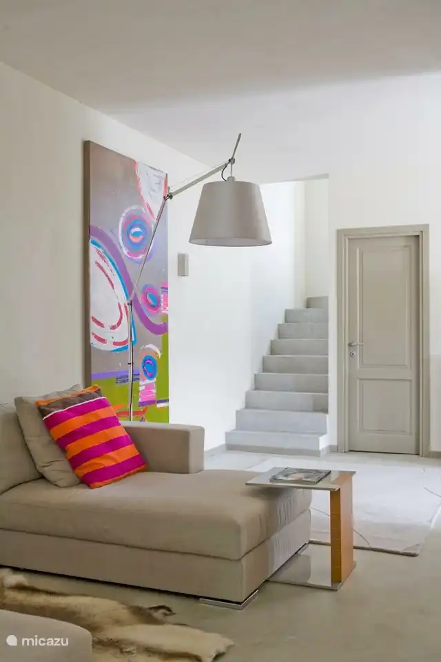 Detail tv lounge met trap naar eerste verdieping 