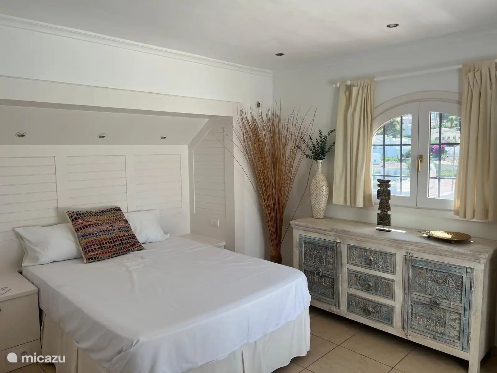 Chambre parentale avec climatisation, une salle de bain et une vue sur la piscine.