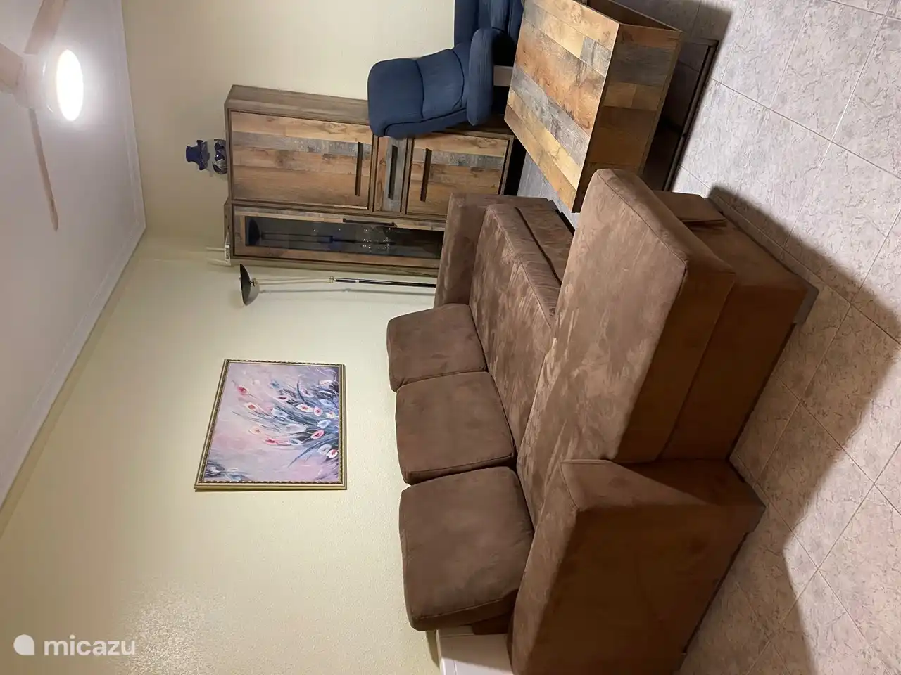 woonkemer met een grote slaapbank en aantal zitplekken 